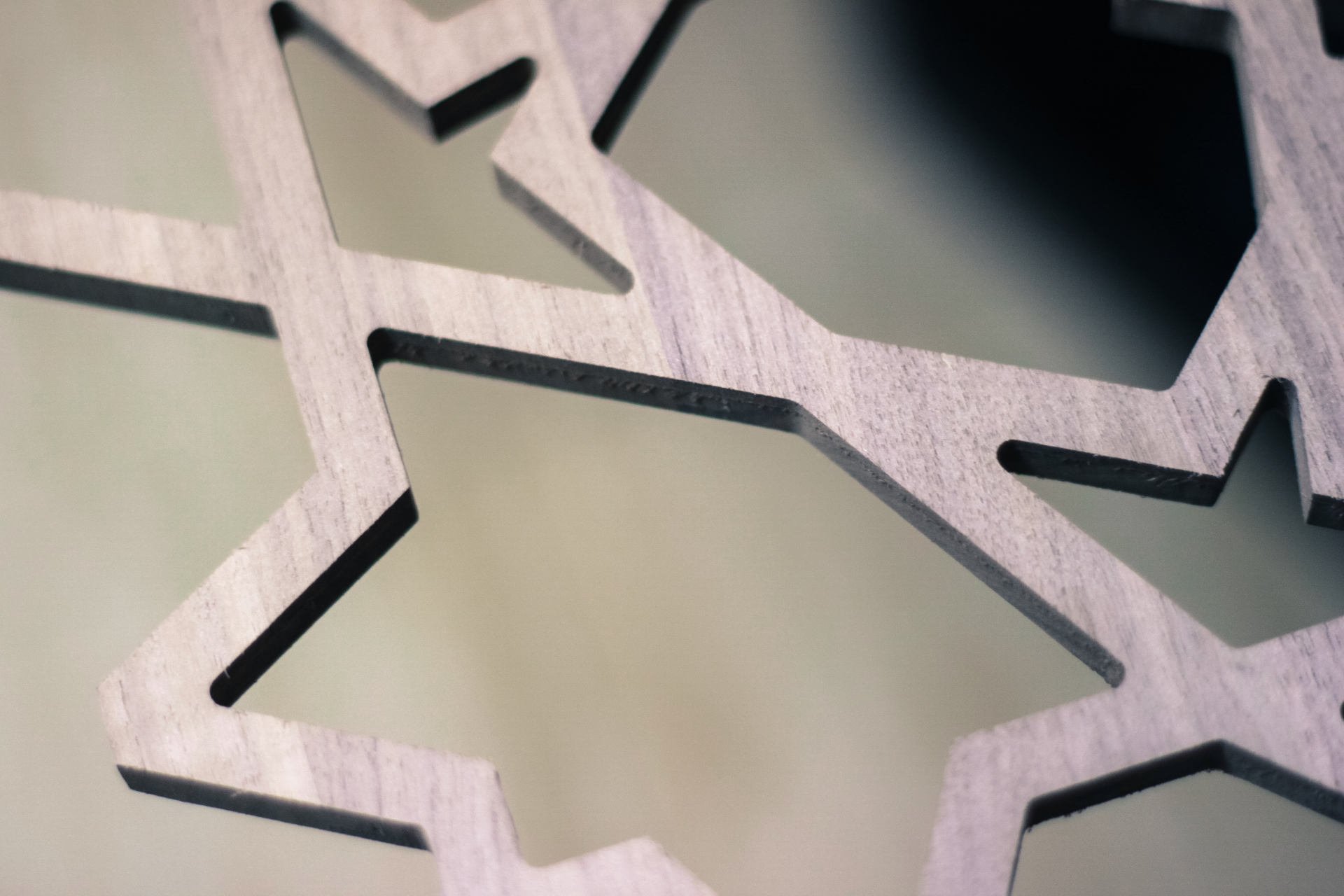 Close-up of precision CNC cut wooden star pattern showing clean laser cutting edges