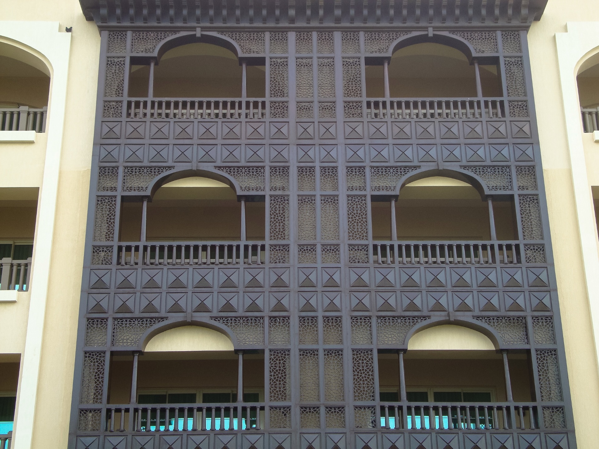 Multi-story building mashrabiya facade featuring traditional Islamic architectural screens